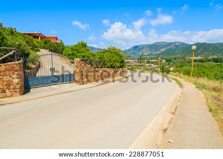 Scenic road in countryside landscape of Sardinia island near Chia beach on sunny summer day, Italy