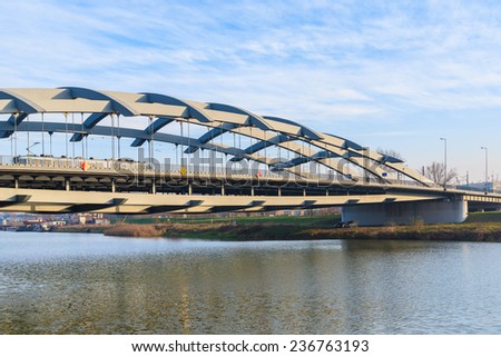 KRAKOW, POLAND - DEC 10, 2014: steel bridge over Vistula river in Krakow. Public transport connects two sides of Krakow city separated by Vistula river.