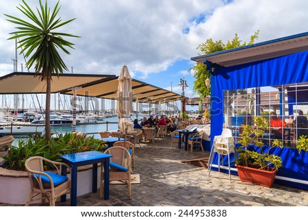 MARINA RUBICON, LANZAROTE ISLAND - JAN 17, 2015: restaurant in port with people dining in Rubicon yacht port. Lanzarote is most northern island in Canary Islands archipelago.