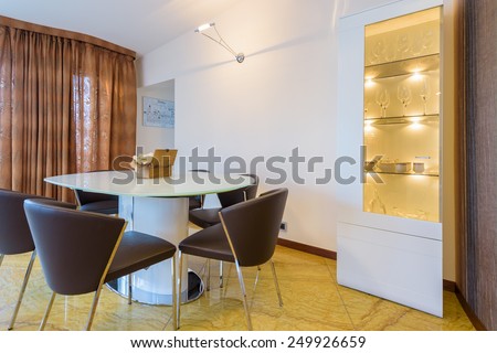 Table with chairs in modern living room interior in luxury apartment, Krakow city, Poland