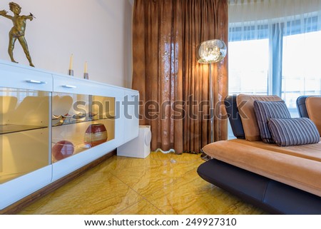 Cabinet with sculpture in modern living room interior with marble floor in luxury apartment, Krakow city, Poland