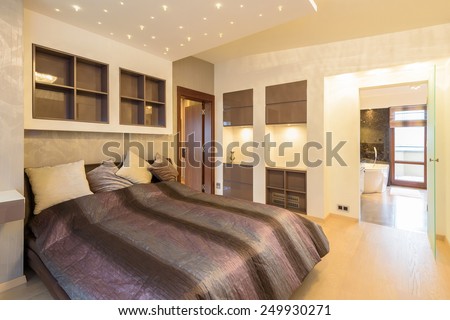Modern bedroom with en suite bathroom in luxury apartment in Krakow city, Poland