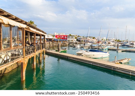 MARINA RUBICON, LANZAROTE ISLAND - JAN 11, 2015: restaurant and pier in Rubicon port, Playa Blanca town. Canary Islands are popular holiday destination due to sunny tropical climate.