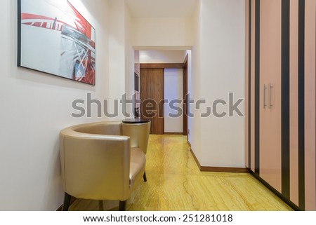 Interior corridor with marble floor and armchair at a modern luxury apartment, Krakow city, Poland