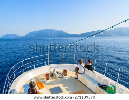 MEDITERRANEAN SEA, GREECE - SEP 19, 2014: tourists on deck of a boat sailing on blue sea. Daily cruise trips take place from Kefalonia island to Ithaka island in summer time.