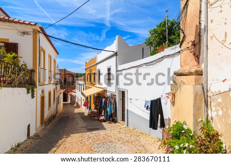 SILVES TOWN, PORTUGAL - MAY 17, 2015: clothes hanging after washing on narrow street in old town of Silves with colorful houses.