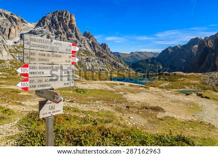 Wooden trail sign with directions for trekkers in Dolomites Mountains near Tre Cime di Lavaredo, Italy