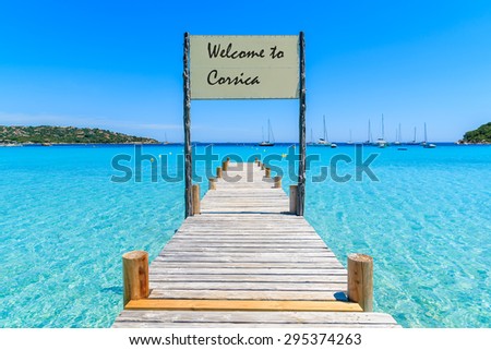 Sign on wooden jetty on Santa Giulia beach with words \