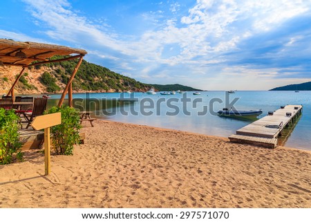 Bar and jetty on Santa Manza sandy beach in early morning light, Corsica island, France