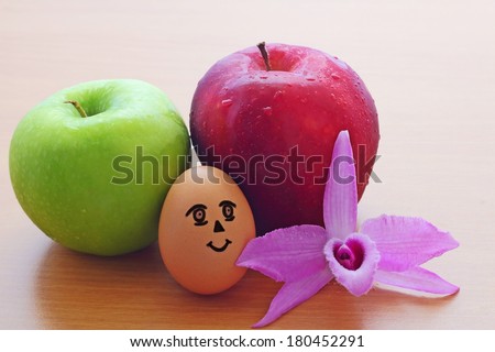 Apples ,Egg and purple orchid on the wooden table