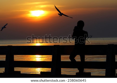 Asian man standing at the sea, silhouette