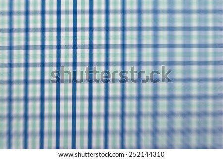Lens blurred colorful checker shirt/fabric background.