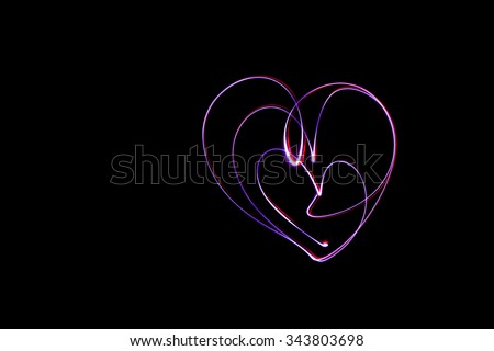 Long exposure small Heart with neon light texture. Abstract neon light.