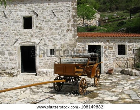 An ancient wooden cart in front of a historical house