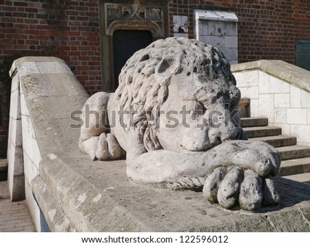 A sculpture of a sleeping lion on a wall of a staircase