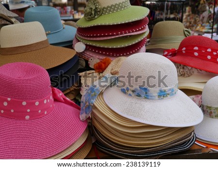 Colonial straw sun hats with ribbons in different colors on a market in Verona in Italy