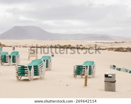 Beach chairs on the beach of Parque Natural de las Dunas de Corralejo. This park is a nature area with sand dunes in the north of the Canary island Fuerteventura belonging to Spain.