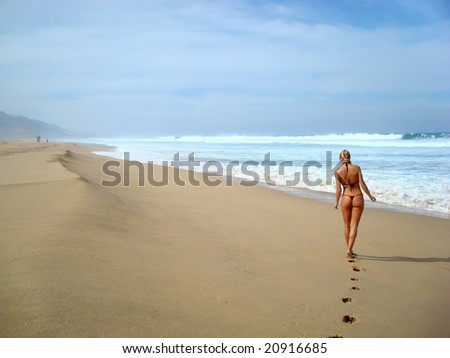 Young lady walking alone along the beach