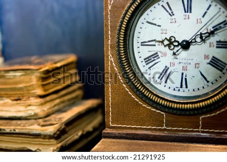 Old books and old clock with leather cover