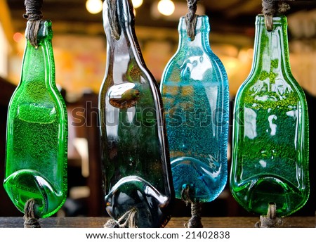 Four melted plastic bottles tied to a wodden barrier