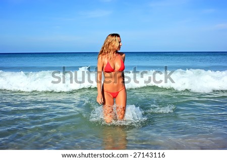 Beautiful blonde girl going out of the waving sea