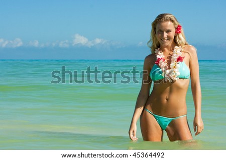 Young blonde girl with slim figure standing in the sea