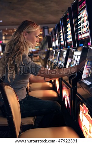 Beautiful blonde girl playing in slot casino