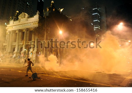 RIO DE JANEIRO, BRAZIL - OCTOBER 15: demonstrators surrounded by tear gas along the city center main avenue, Rio Branco and next to the Municipal Theater, during demonstrations in support to the teacher\'s strike as the annual October 15 Teachers\' Day holi