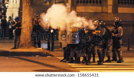 RIO DE JANEIRO, BRAZIL - OCTOBER 15: Anti- riot police battalion fire pepper gas bombs against demonstrators along the city center main avenue, Rio Branco, during a protest in support the teacher\'s strike as the annual October 15 Teachers\' Day holiday cam