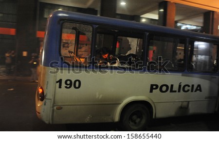 RIO DE JANEIRO, BRAZIL - OCTOBER 15: Anti-Riot police officer attempt to control a fire set inside a police bus along the city center main avenue, Rio Branco, during a protest in support to the teacher\'s strike as the annual October 15 Teachers\' Day holid