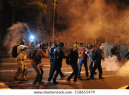 RIO DE JANEIRO, BRAZIL - OCTOBER 15:  protesters and jornalistas are surrounded by tear gas on a barricade along the city center main avenue, Rio Branco, in support to the teacher\'s strike as the annual October 15 Teachers\' Day holiday came to a violent c