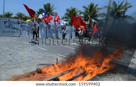 RIO DE JANEIRO, BRAZIL - 21 OCTOBER 2013: Oil workers demonstrators faces the National Force Security Battalion behind the barricades at the Barra da Tijuca beach.