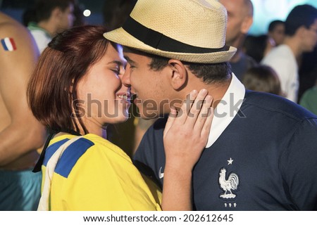 RIO DE JANEIRO, BRAZIL - JUNE 20, 2014: An Ecuatorian soccer fan and a French soccer fan kisses at the FIFA Fan Fest in Copacabana on June 20, 2014 in Rio de Janeiro, Brazil, during the match of their countries. No use in Brazil.