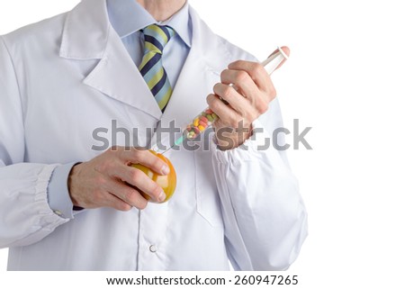 bust of a man wearing medical white coat, light blue shirt and glossy regimental tie white dark, light blue and green stripes, making an injection to green beefsteak tomato with syringe full of pills