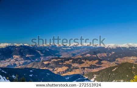 White snowy Dolomites mountains with rocks, snow-capped peaks and green conifers in winter