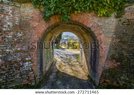 A small gallery through grunge brick walls allows you to get out on a green country road