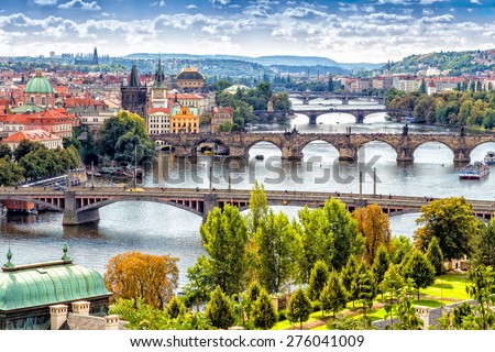 Scenic view of bridges on the Vltava river and of the historical center of Prague: buildings and landmarks of old town with red rooftops and multi-coloured walls.