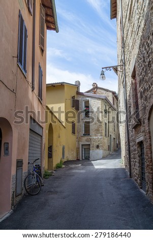 Old houses facing each other in a street in the old town of a country town in Italian countryside