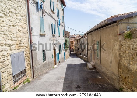 Old houses facing each other in a street in the old town of a country town in Italian countryside