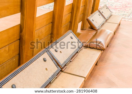 kneeler with leather cushion to support the knees of the faithful who pray in a Catholic Italian church