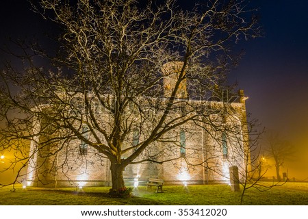 night view of ancient brick walls of an old Catholic church with one of the oldest  belltowers in Italy