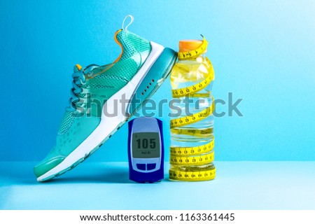 Concept of a healthy lifestyle. Diabetes. Sugar diabetes. Sports diabetics. Detox water, glucose meter, measuring tape and sneakers on a blue background.