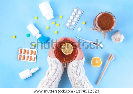 Medications, pills, thermometer, traditional medicine for treating colds, flu, heat on a blue background. Maintenance of immunity. Seasonal diseases. Top view. Medicine flat lay