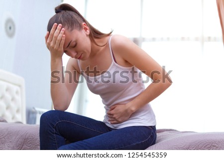 Young woman feels bad and experiences abdominal pain during the period of PMS and menstruation. Painful menstruation. Inflammation and Bladder Infection. Copy space