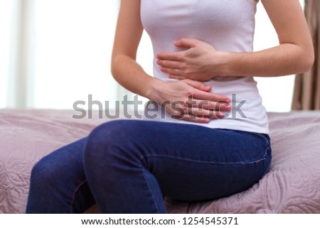 Young woman feels bad and experiences abdominal pain during the period of PMS and menstruation. Painful menstruation. Inflammation and Bladder Infection