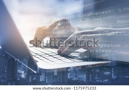 Double exposure business man working on laptop computer and the city. Software developer, programmer coding internet mobile app, modern technology, smart business, internet of things IoT concept.