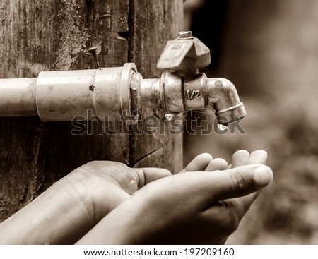 Water dropped from the old tap on hand in dry season, rural area Thailand.