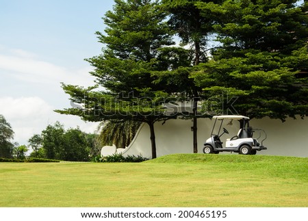 Golf cart park in front of green golf court, landscape.