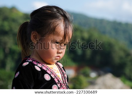 MON JAM, CHIANGMAI, THAILAND - OCTOBER 25: Unidentified Hmong girl in traditional dress  watching something, sunny day on 25 October 2014 in Mon Jam, Chiangmai, Thailand.