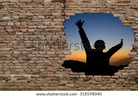 Silhouette of man outside the broken old brick wall with room for text, transformation concept, life transformation.